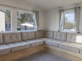 A snug area with a corner sofa and windows at WF32 - Jurassic Discovery in Charmouth