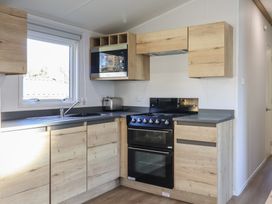 A kitchen with wooden cabinets and appliances at WF32 - Jurassic Discovery, Charmouth