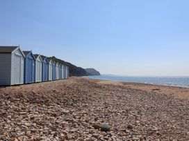 A row of beach huts by the sea at WF32 - Jurassic Discovery, Charmouth