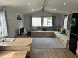 A living room with a sofa and television at Jurassic Discovery in Charmouth