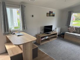 A living room with a table and sofa at Jurassic Discovery in Charmouth