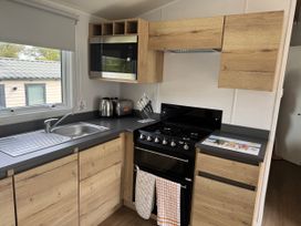 A kitchen with a sink and cooking stove at Jurassic Discovery in Charmouth