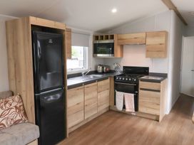 A kitchen with refrigerator, sink, and stove at Jurassic Discovery in Charmouth