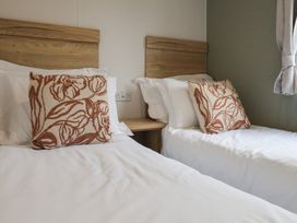 A bedroom with two beds and decorative pillows at Jurassic Discovery in Charmouth