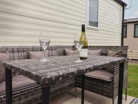 An outdoor seating area with a table and wine on display at Jurassic Discovery in Charmouth