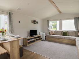 A living room with a sofa and television at Jurassic Discovery in Charmouth