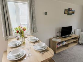 A dining area with a table set for meals at Jurassic Discovery in Charmouth