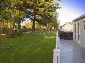 An outdoor area with a deck and grass in Orchid 9 Christchurch