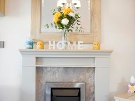 A living room with a fireplace and flowers at Orchid 9 Christchurch