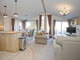 A living room with a sofa, dining area and television at Orchid 9 Christchurch