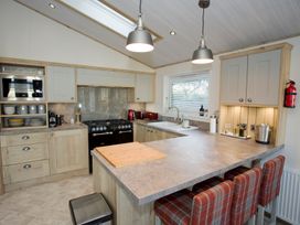 A kitchen with cabinets and a gas stove at Orchid 9 Christchurch