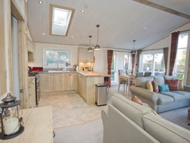 A kitchen with an island and dining area at Orchid 9 in Christchurch