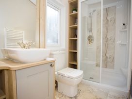 A bathroom with a sink, toilet, and shower at Orchid 9 in Christchurch