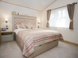 A bedroom with a bed and bedside table at Orchid 9 Christchurch