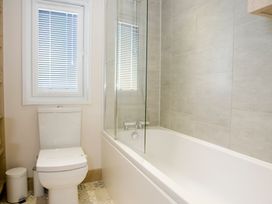 A bathroom with a bathtub and a toilet at Orchid 9 in Christchurch