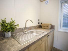 A kitchen area with a sink and storage box at Orchid 9 Christchurch