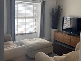 A living room with a tv and sofa at Penmaenmawr Coastal Retreat