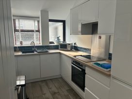 A kitchen with appliances and sink at Penmaenmawr Coastal Retreat