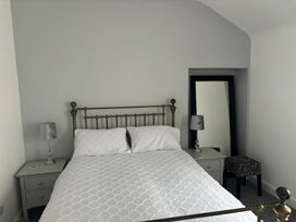 A bedroom with a bed and nightstand at Penmaenmawr Coastal Retreat 