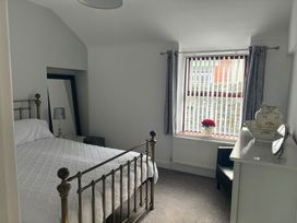 A bedroom with a bed and window at Penmaenmawr Coastal Retreat