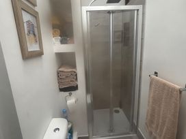 A bathroom with a shower and towels at Penmaenmawr Coastal Retreat