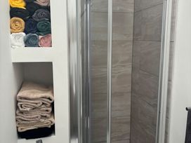 A bathroom featuring a shower and neatly arranged towels at Penmaenmawr Coastal Retreat