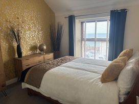 A bedroom with a bed and window at Penmaenmawr Coastal Retreat