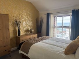 A bedroom with a bed and furniture at Penmaenmawr Coastal Retreat