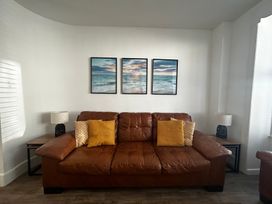 A living room with a brown sofa and wall art at The Weymouth House in Weymouth