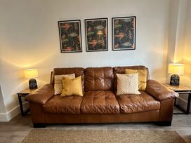 A living room with a sofa and pictures on the wall at The Weymouth House in Weymouth