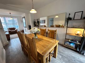 A dining room with a wooden table and chairs at The Weymouth House in Weymouth