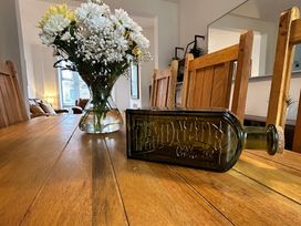 A dining room with a table and vase of flowers at The Weymouth House in Weymouth