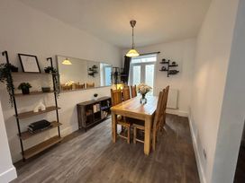 A dining room with a wooden table and chairs at The Weymouth House in Weymouth