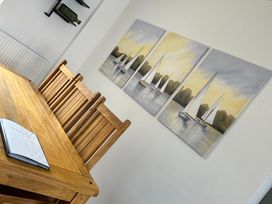 A dining table with chairs and a painting on the wall at The Weymouth House in Weymouth