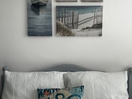 A bed with pillows and wall art at The Weymouth House in Weymouth