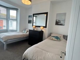A bedroom with two beds and a dresser at The Weymouth House in Weymouth