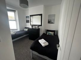 A bedroom with two beds and a dresser at The Weymouth House in Weymouth