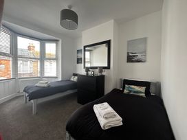 A bedroom with two beds and a dresser at The Weymouth House in Weymouth