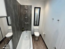 A bathroom with a bathtub and a toilet at The Weymouth House in Weymouth