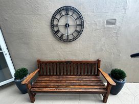 A bench with a clock on the wall at The Weymouth House in Weymouth