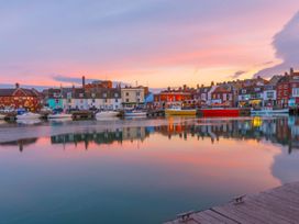 A waterfront view with boats and buildings at The Weymouth House in Weymouth