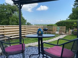 A garden with table and chairs, grill, and path at The Haven in Penrith