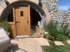 An entrance with a wooden door and flowers at Cosy Escape in Sheerness