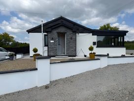 A house with a stone facade and garden features at Cherry Chirp Cottage Enniskillen