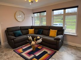 A living room with a sofa and decorative elements at Cherry Chirp Cottage Enniskillen