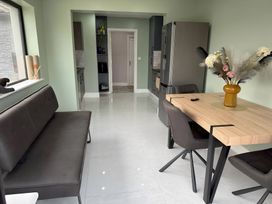 A kitchen with a dining area and refrigerator at Cherry Chirp Cottage in Enniskillen