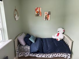A bedroom with a bed and teddy bear at Cherry Chirp Cottage Enniskillen