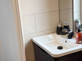 A bathroom with a sink and toiletries at Cherry Chirp Cottage in Enniskillen