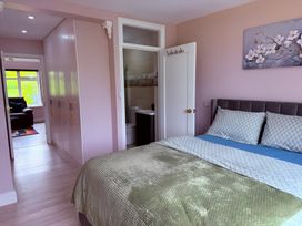 A bedroom with a bed and adjoining bathroom at Cherry Chirp Cottage in Enniskillen
