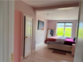 A bedroom with a bed and window at Cherry Chirp Cottage Enniskillen